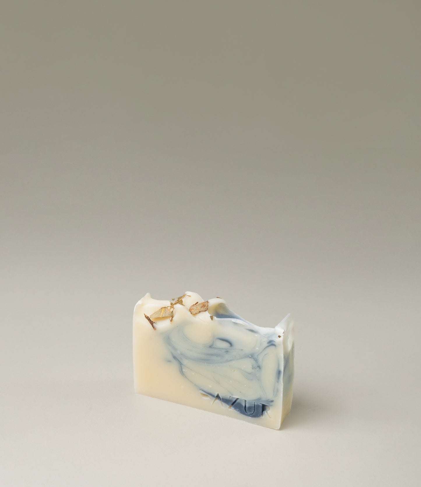 Mighty Mint Natural Soap from Azur Natural BodyCare. It's color vary from vanilla to medium blue. The top of this handmade soap is sprinkled with the ingredients of the item.