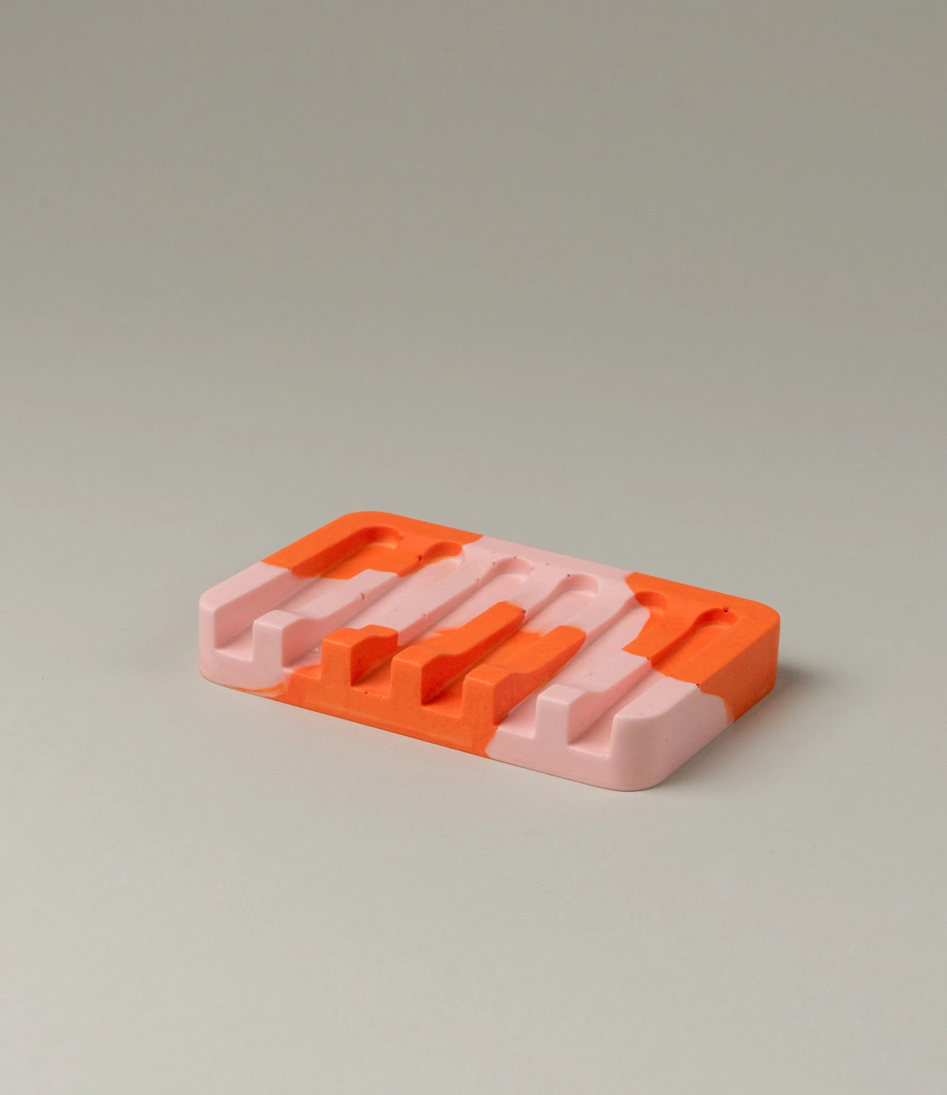 Soap Holder from Gritful Homeware in the maximalist color pairing of light rose and orange. The soap dish has a rectengular shape which contrasts the pattern of the item, which is more organic.