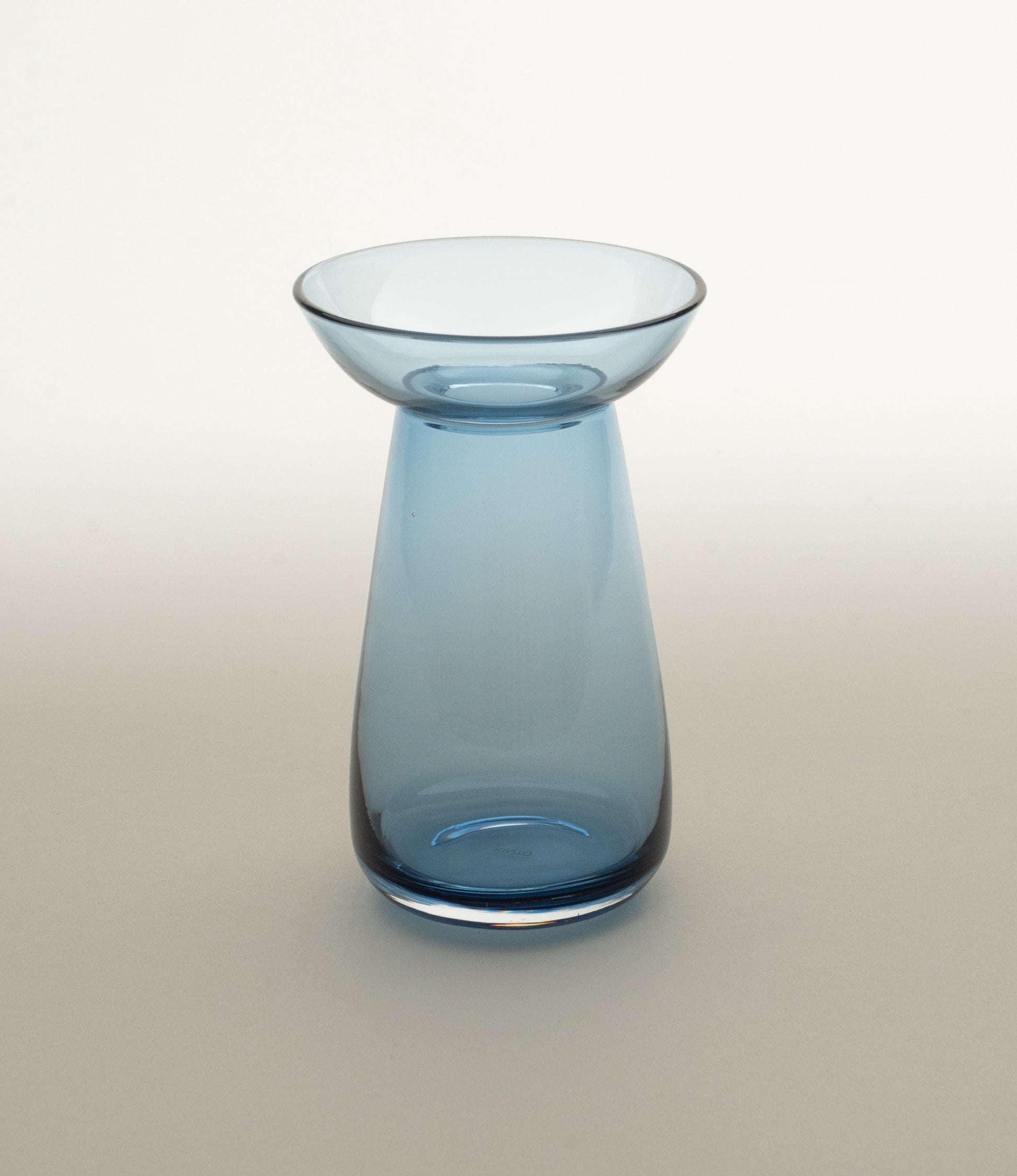 Aqua Culture Vase small from Kinto is a vase to grow new plants. The vase consists of two pieces, a base and a dish for the top, which holds the bulbs, seeds or leaves. This variant is made of a blue glass.